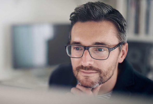 Berater schaut konzentriert auf PC